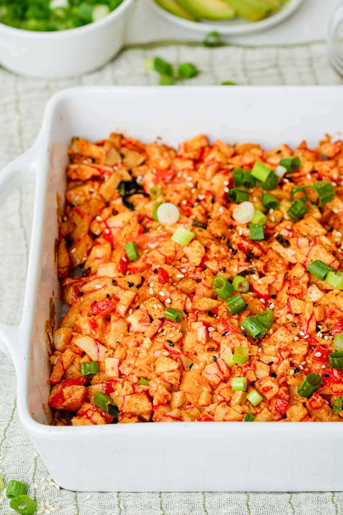 baked sushi casserole with green onions on top.