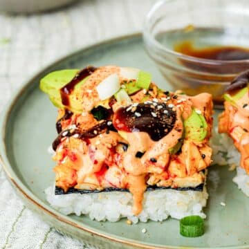 a slice of sushi bake on a plate with sauce on top.