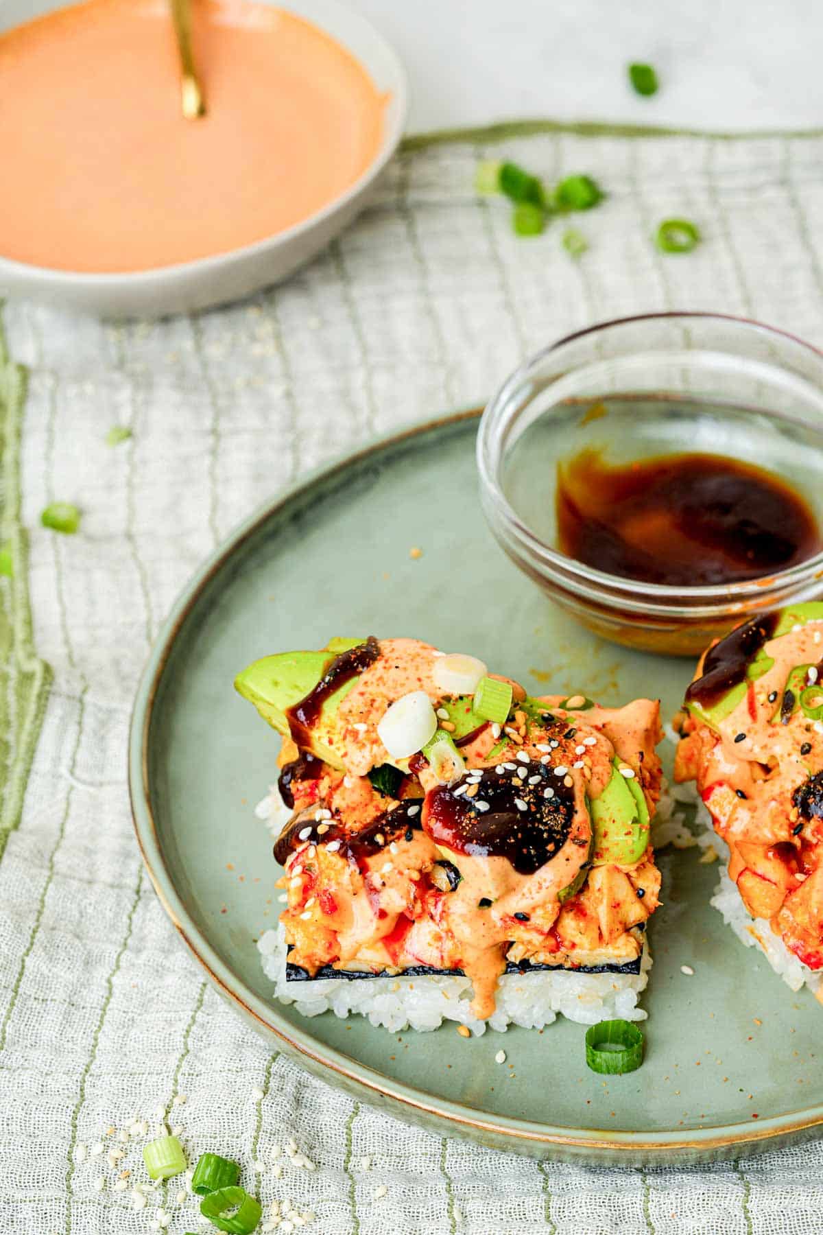 sushi bake pieces on a plate with sauce on the side.