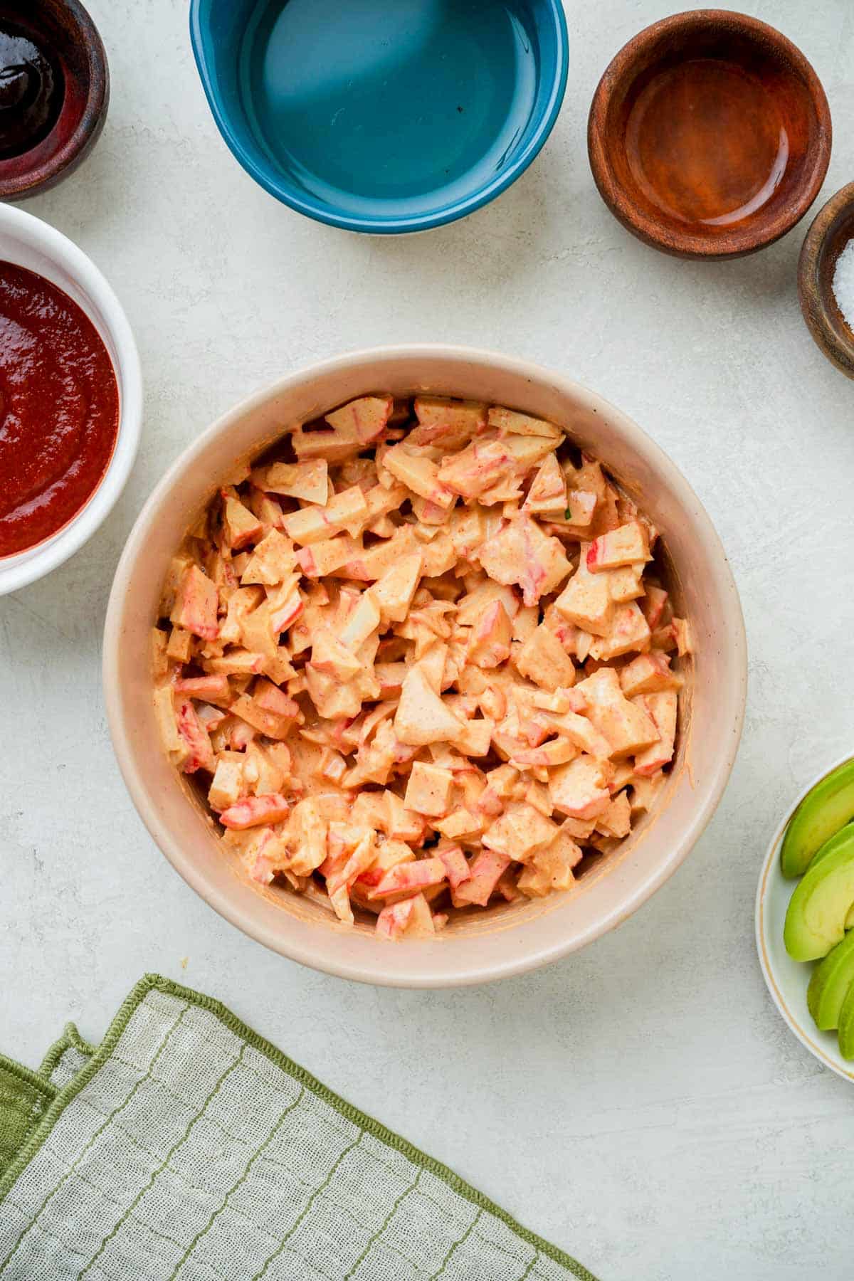 imitation crab mixed in an orange sauce in a bowl.