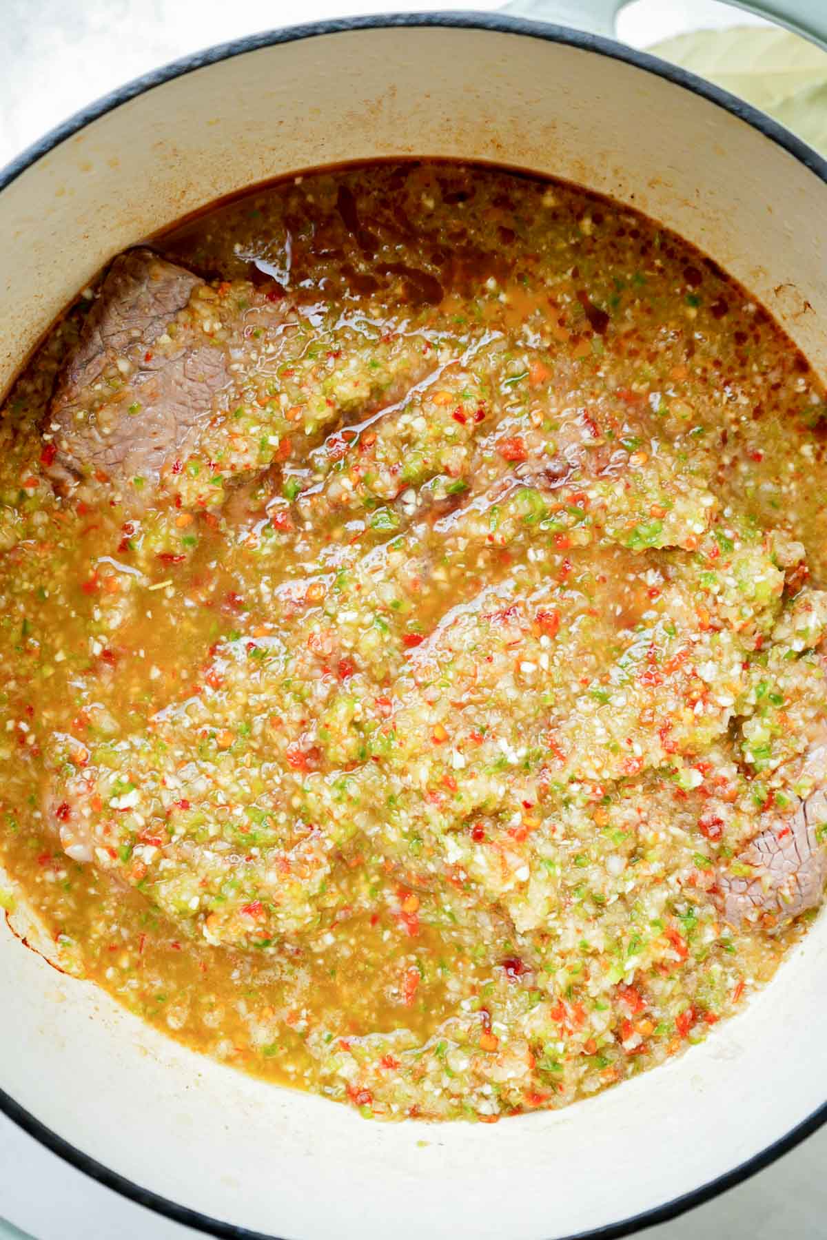 a green puree on top of a roast in a pot.