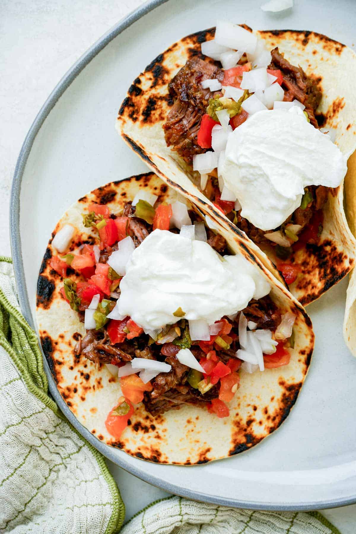 2 tacos with sour cream on a plate