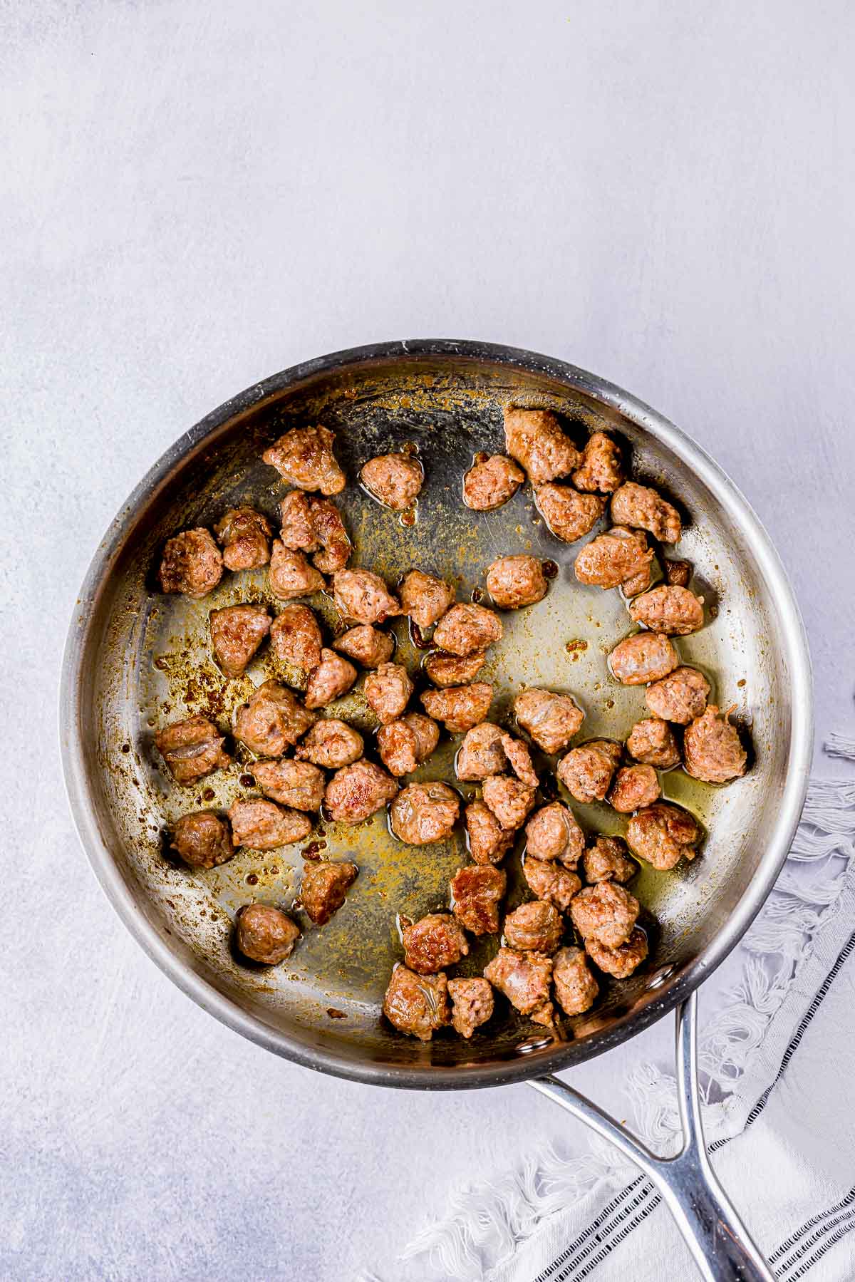 sausage pieces browned in a skillet.