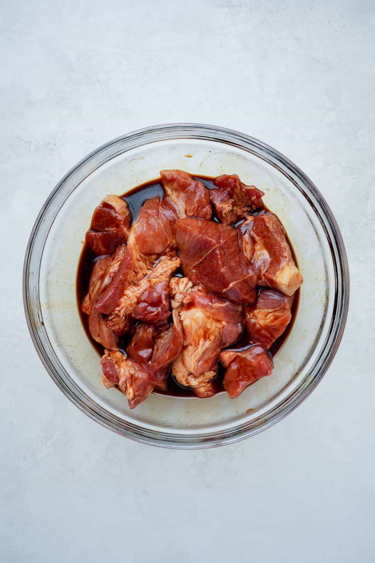 raw pork mixed with red sauce in a bowl.