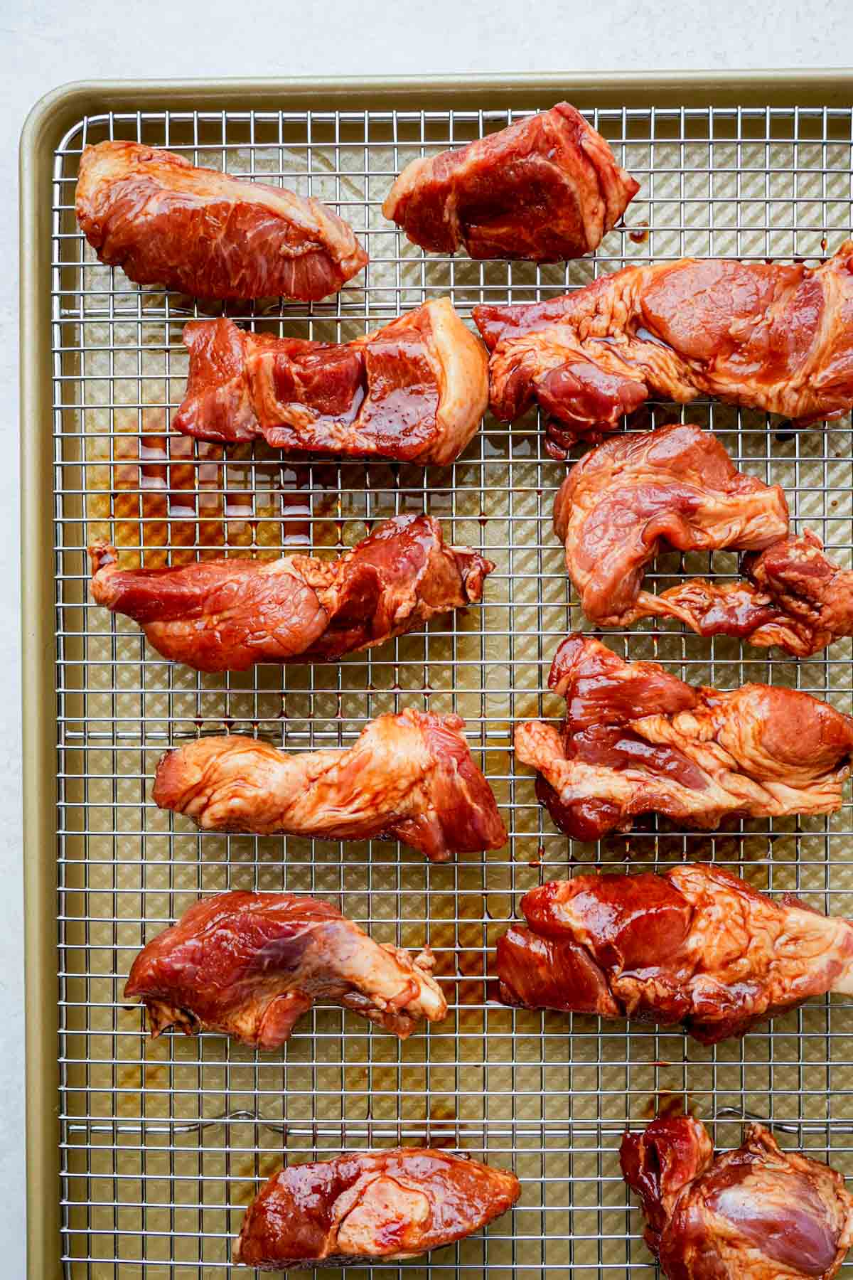 marinated raw pork on a baking rack.