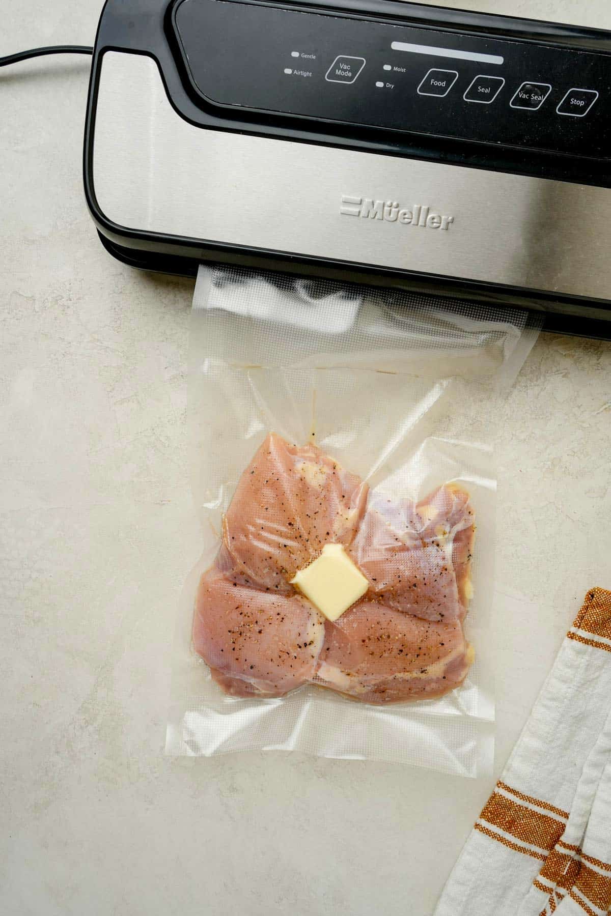 raw chicken thighs and butter in a vacuum seal bag.