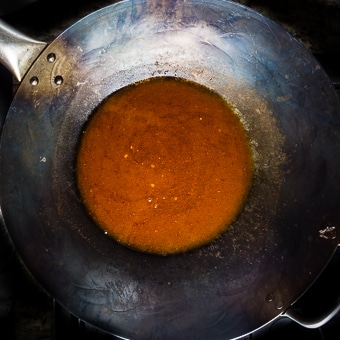 an orange sauce in a wok.