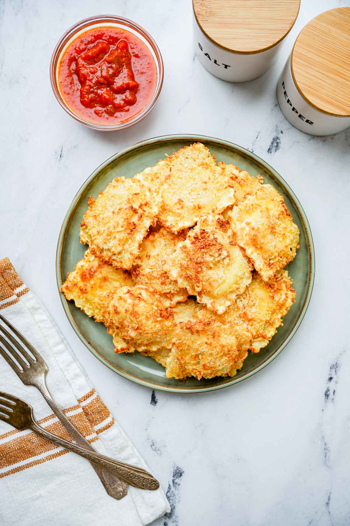 a plate of fried ravioli with marinara on the side.