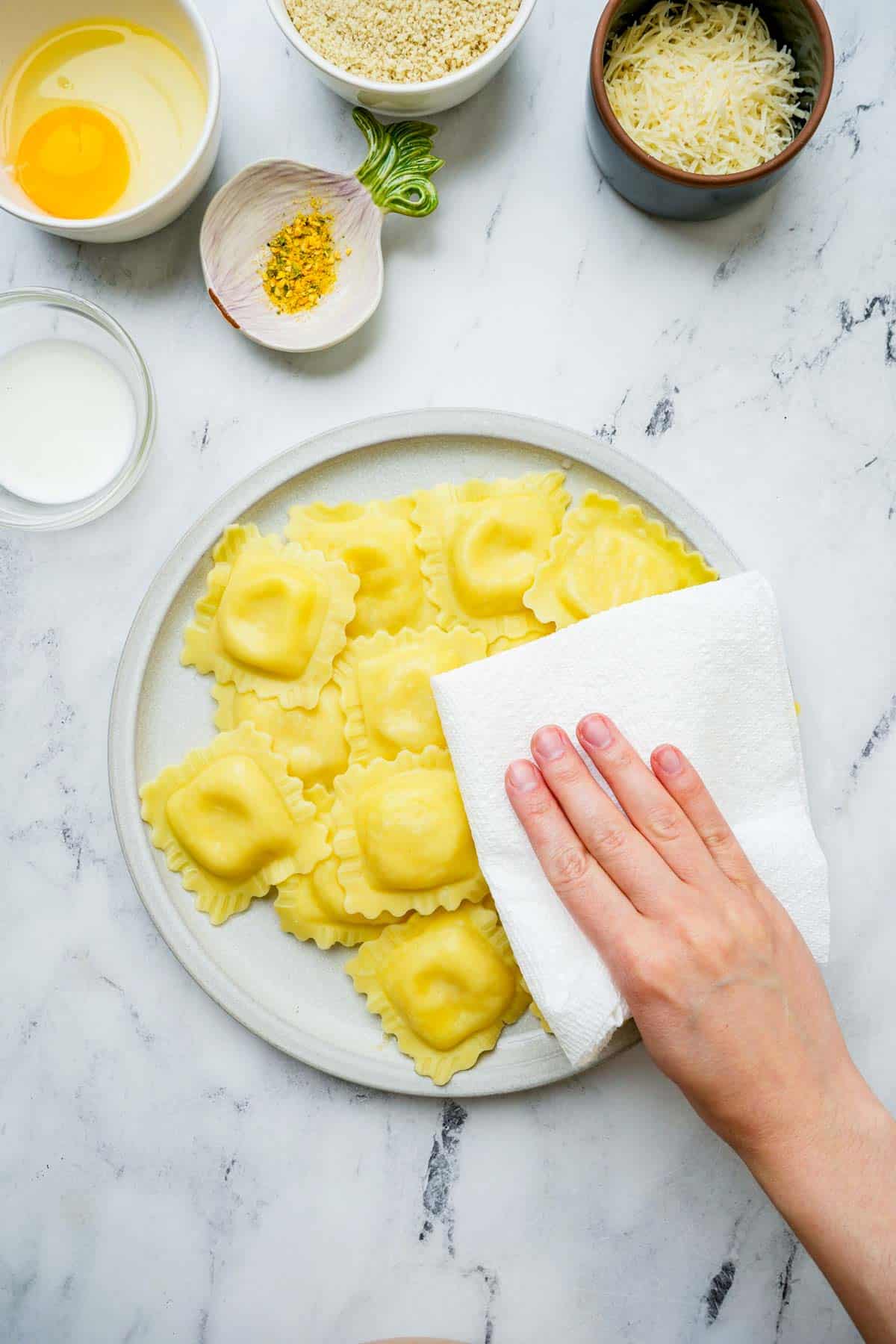 patting ravioli dry with a peper towel.