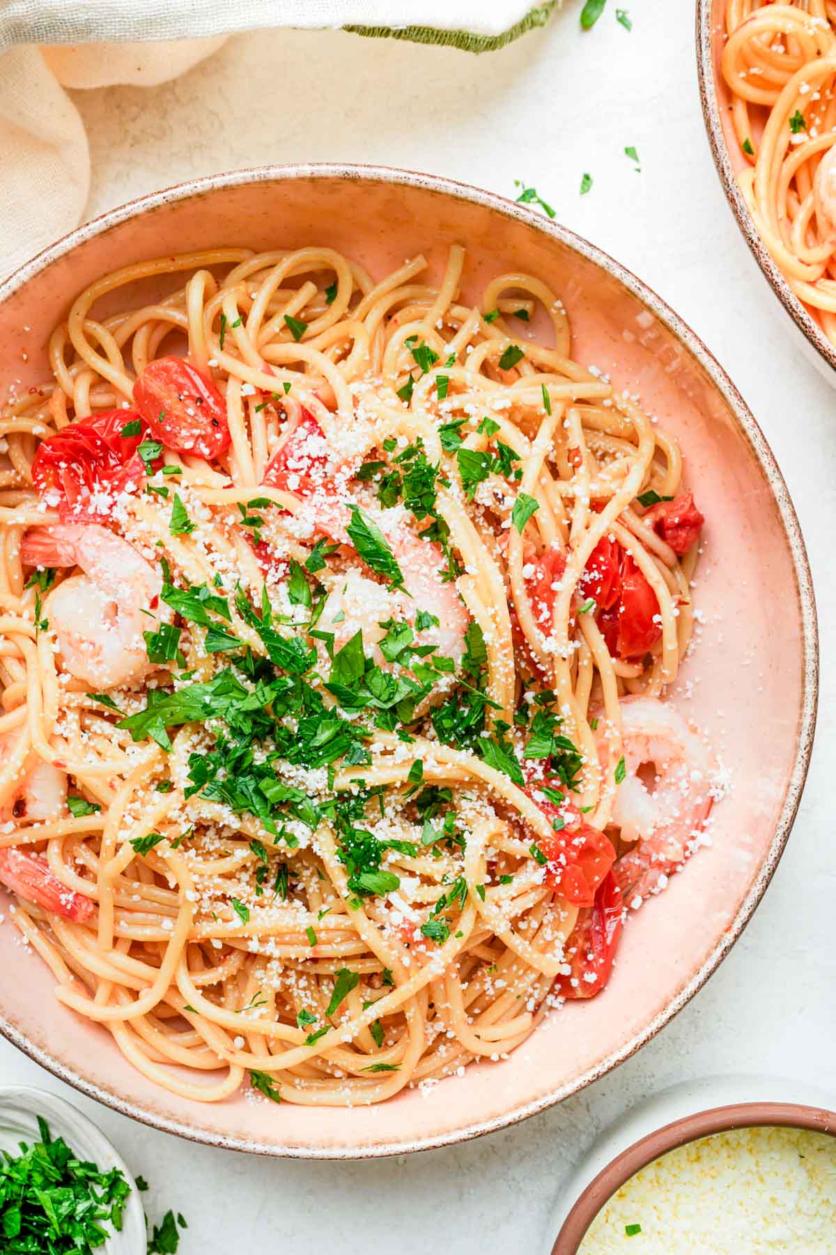 a bowl of pasta with shrimp and tomatoes.