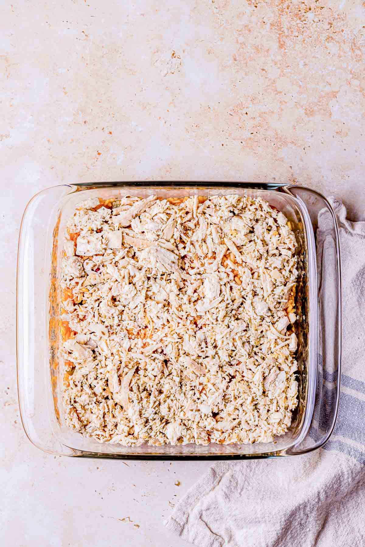 shredded chicken spread in a baking dish.