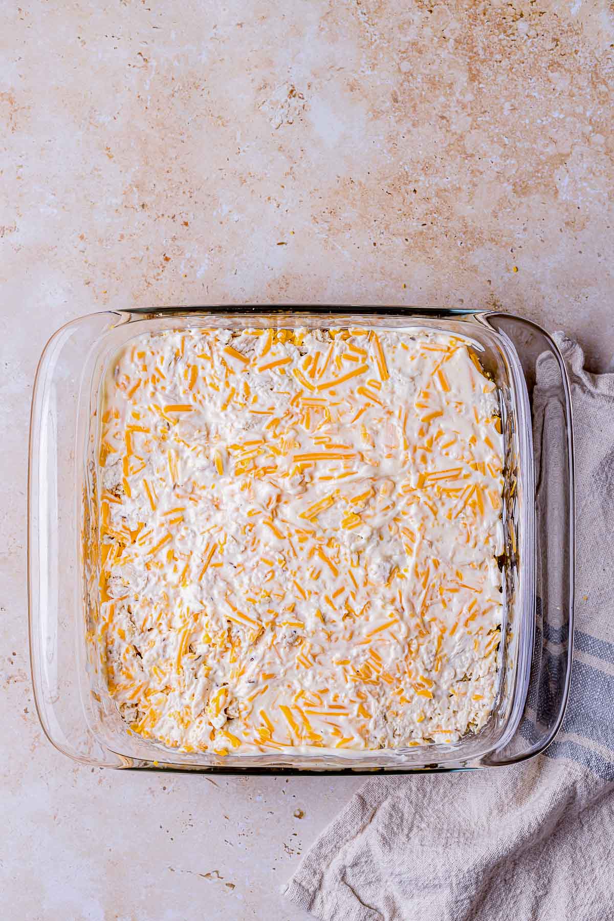 mayonnaise spread over chicken in a baking dish.