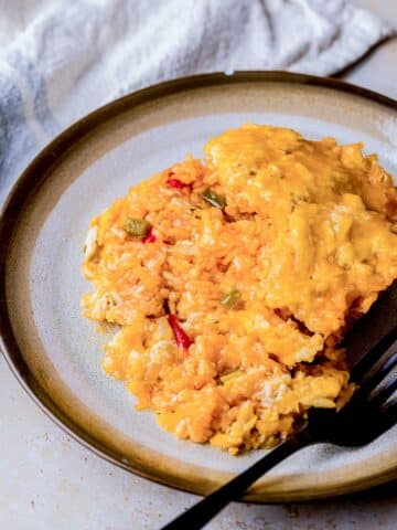 a plate of cuban rice and cheese with a fork.