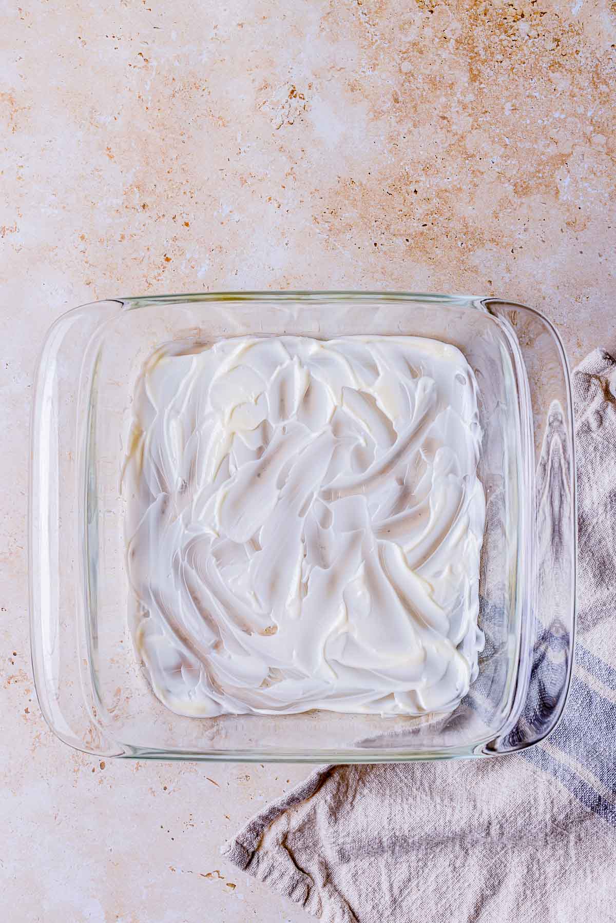 mayonnaise spread in the bottom of a baking dish.