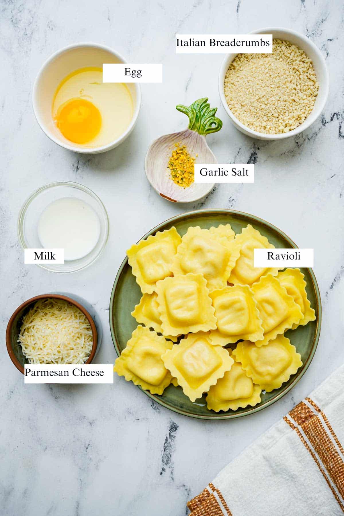 ingredients for air fryer ravioli on a white board with labels.