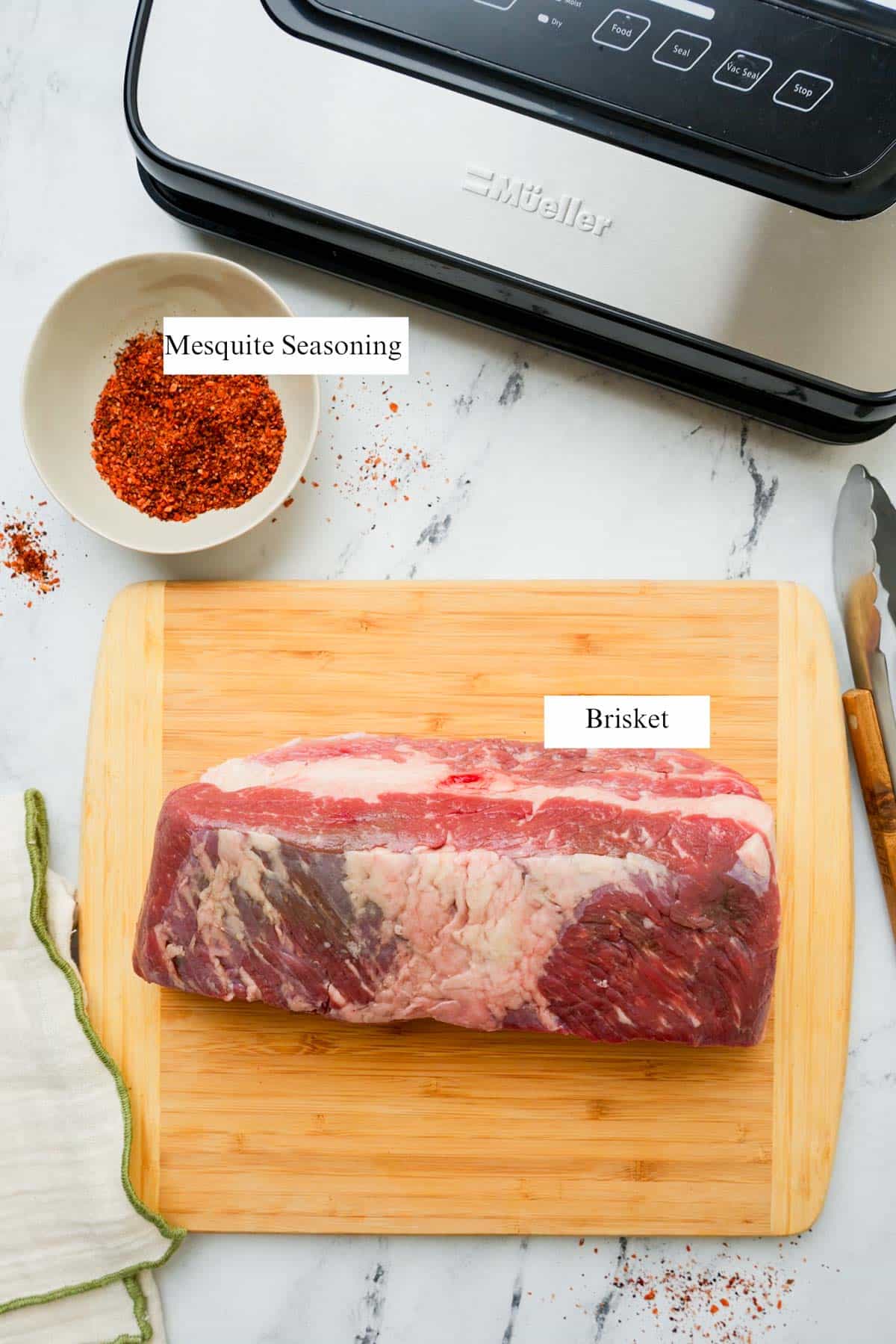 ingredients for sous vide brisket on a cutting board and counter with labels.