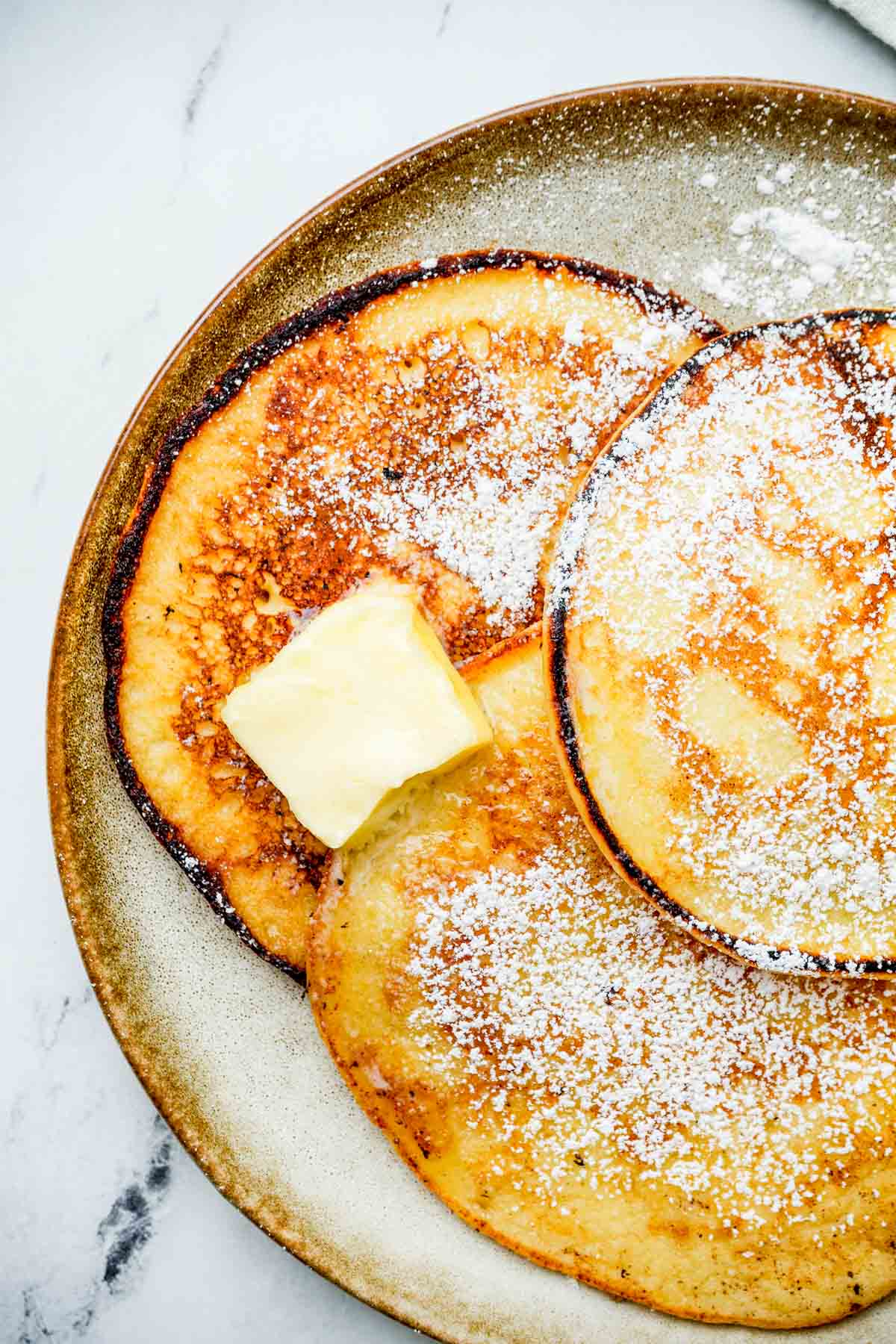 a plate of pancakes with butter on top.