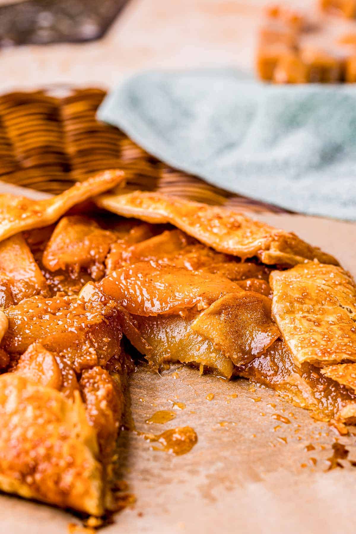 a sliced apple galette on a brown surface.