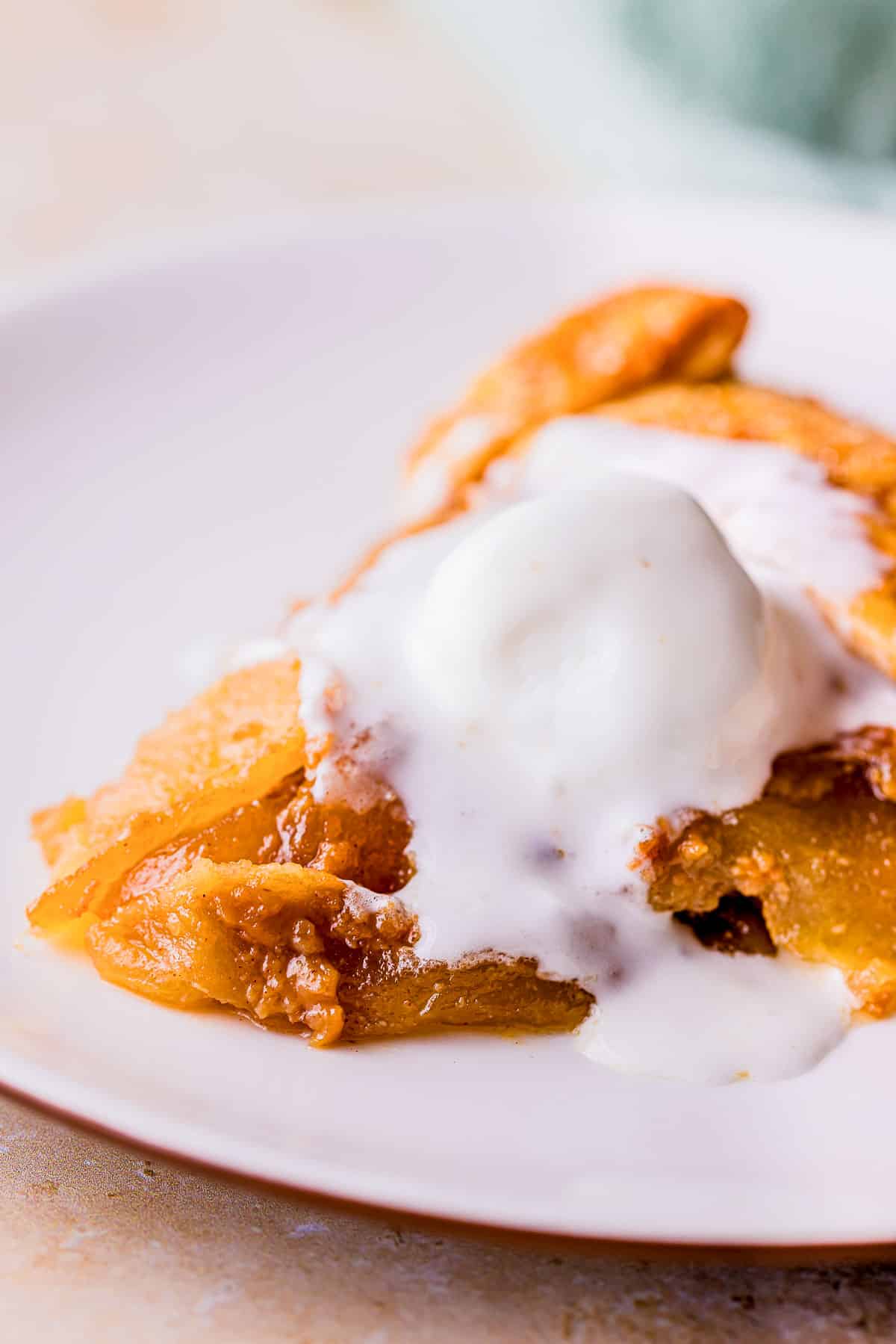 a piece of apple galette with ice cream on top on a plate.