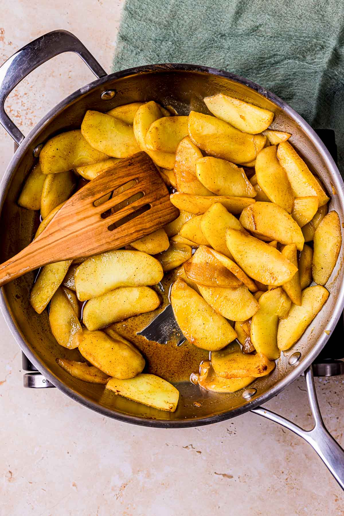 apple slices and caramel cooking in a skillet.