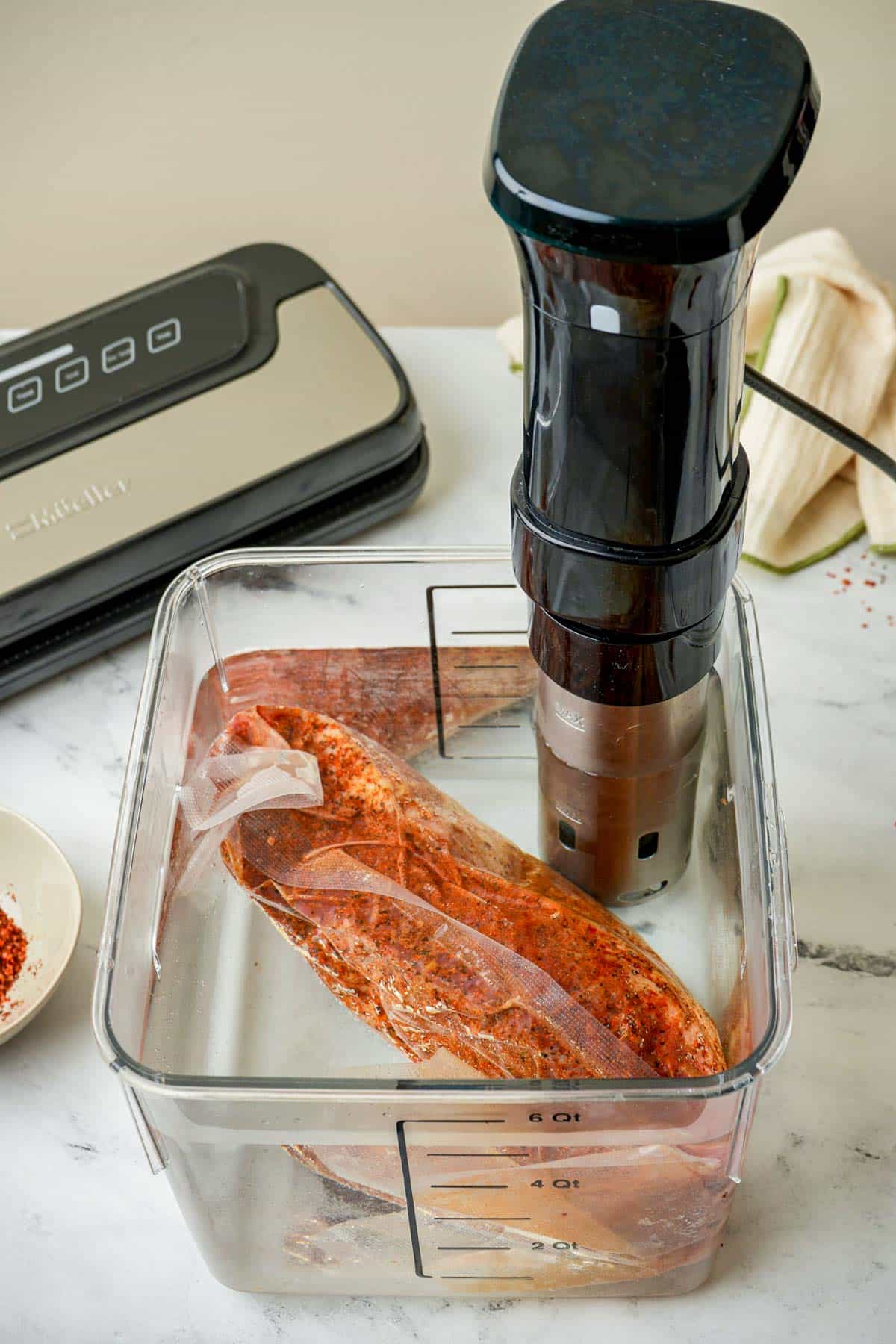 vacuum sealed beef cooking in a sous vide water bath.