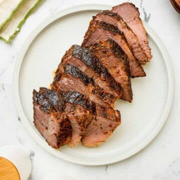 sliced brisket on a white plate.