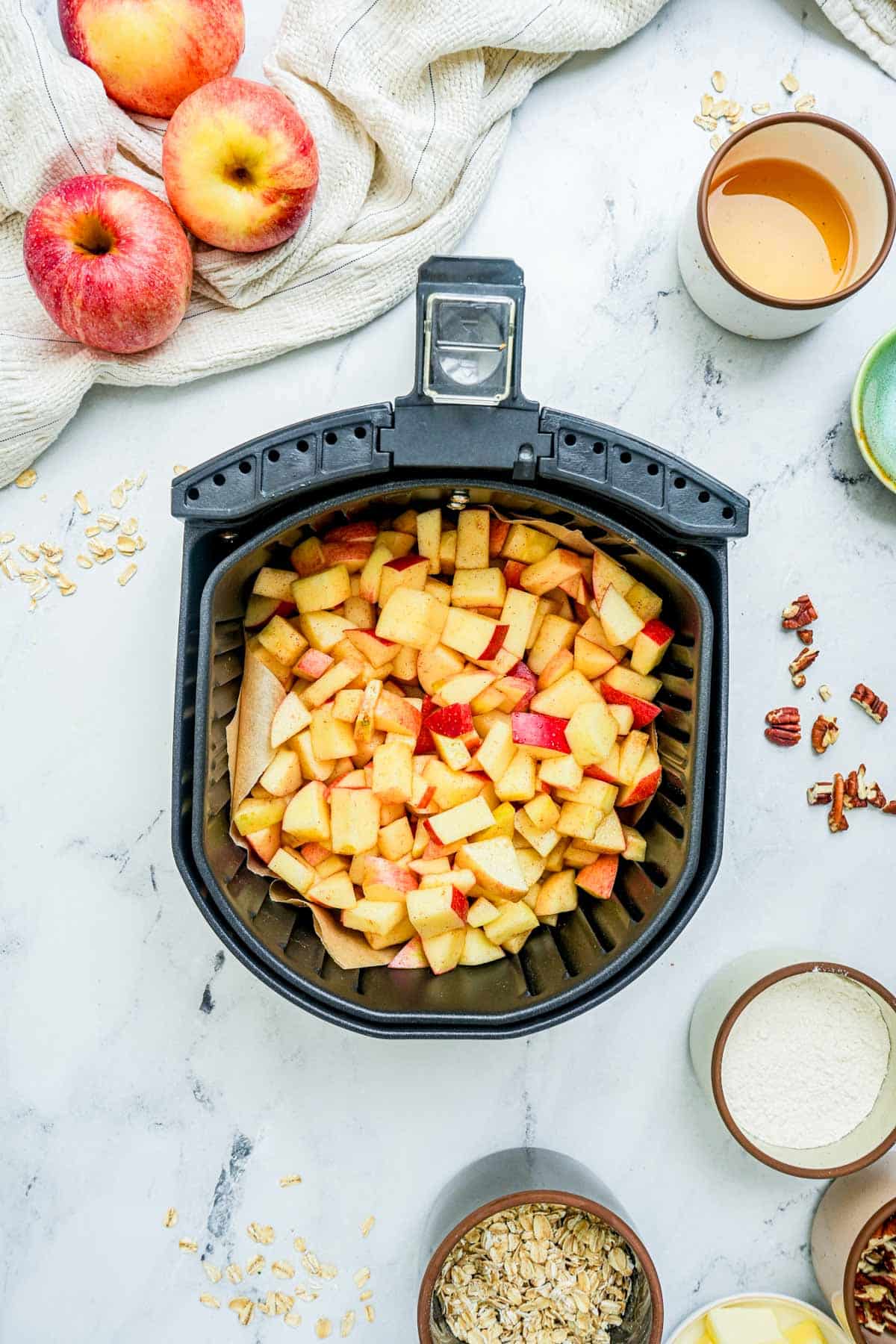 cut up apples in an air fryer basket.