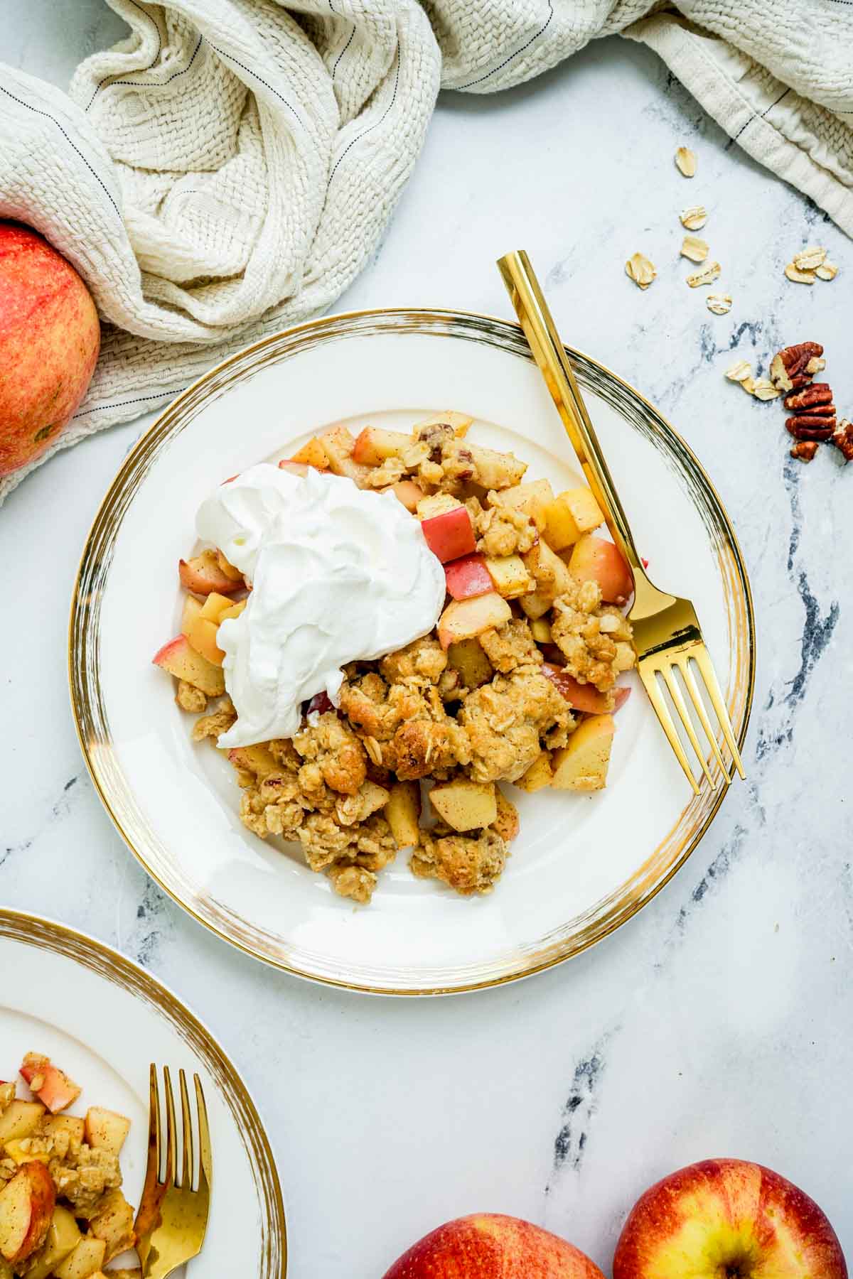 apple crisp on a plate with whipped cream.