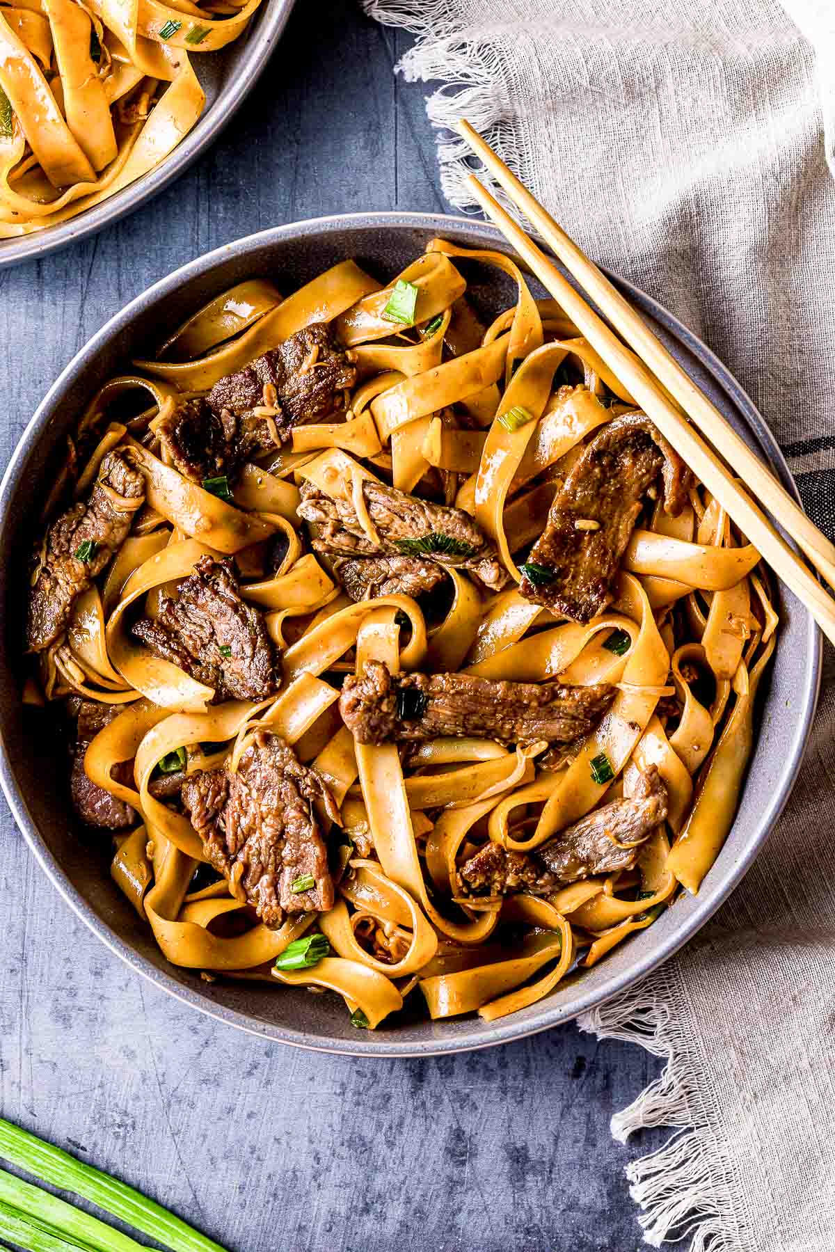 beef ho fun noodles with chopsticks on the side.