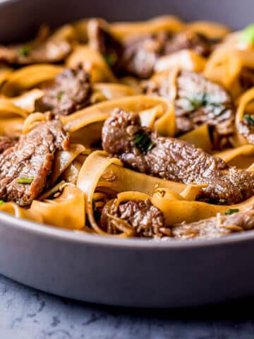 strips of beef with saucy noodles in a bowl.