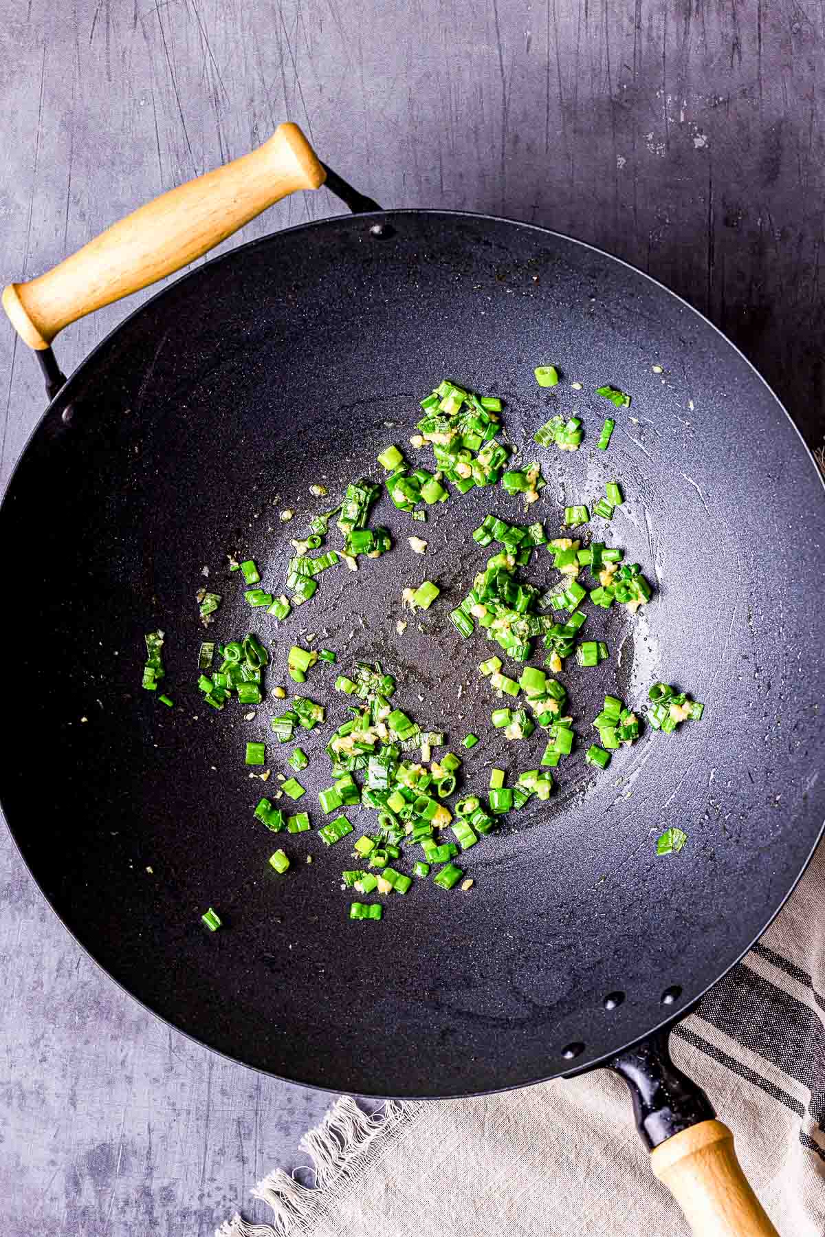 green onions cooking in a wok.