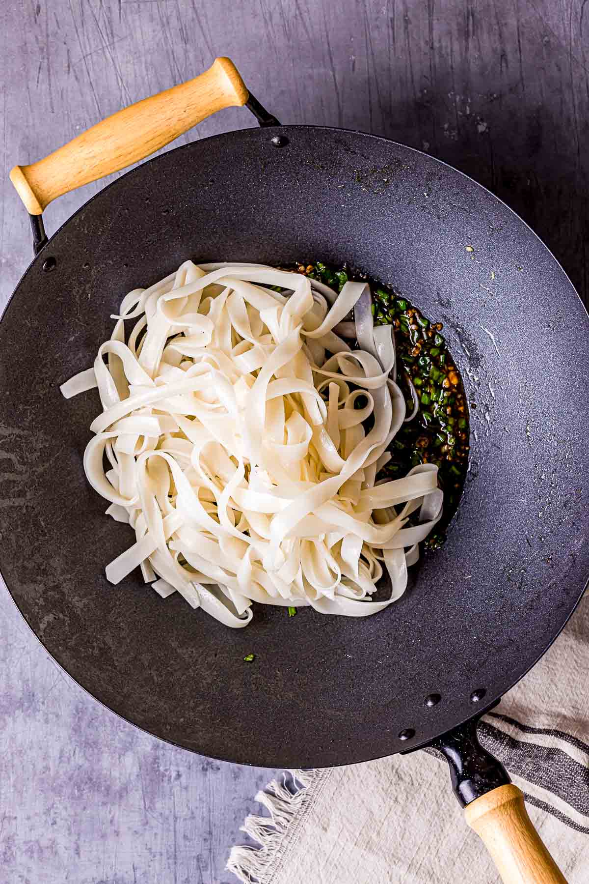 rice noodles cooking in a wok.