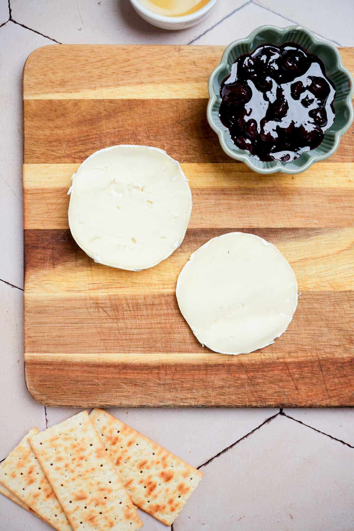 brie wheels on a cutting board.