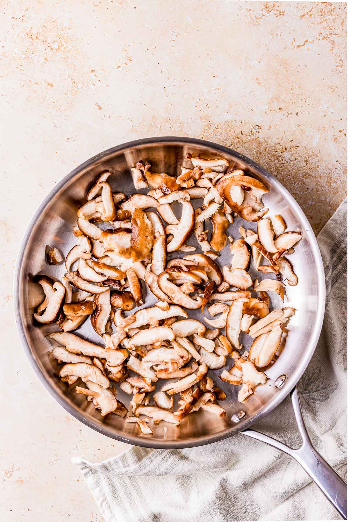 sliced raw mushrooms in a skillet.