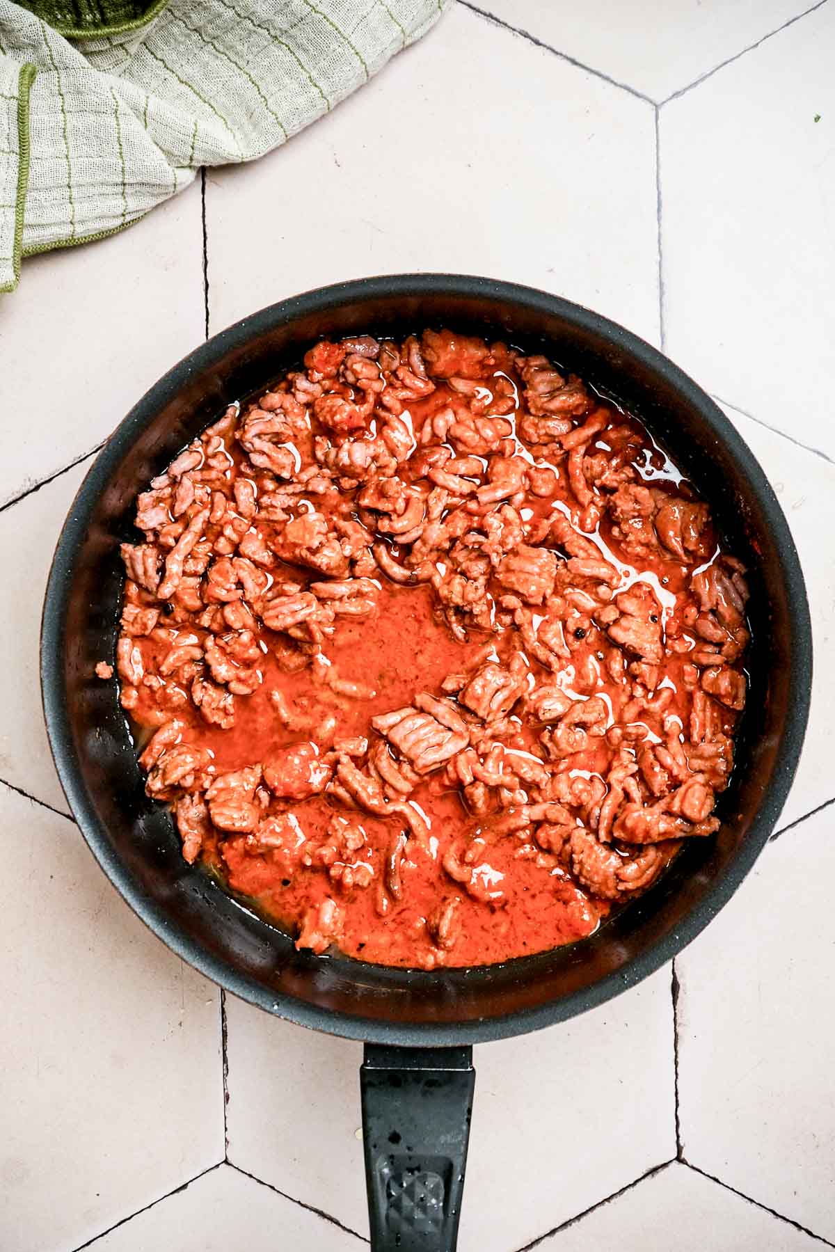 ground beef in red sauce cooking in a skillet.