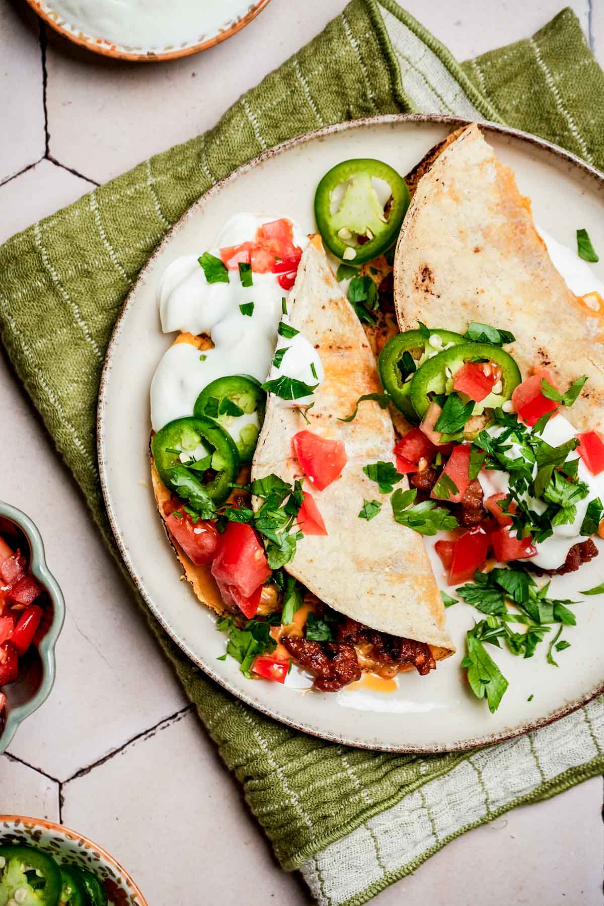 2 ground beef tacos with cilantro, jalapenos and sour cream.