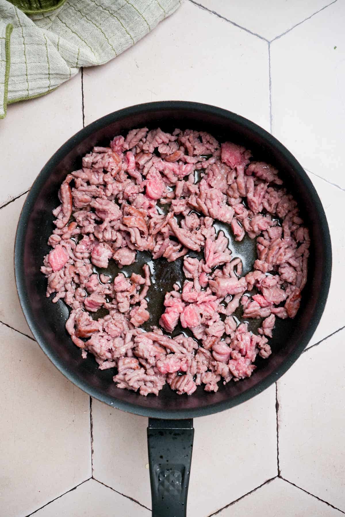 ground beef cooking in a skillet.