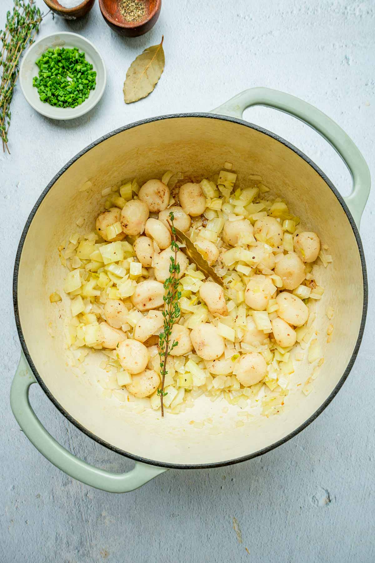 onions, chestnuts and thyme cooking in a pot.