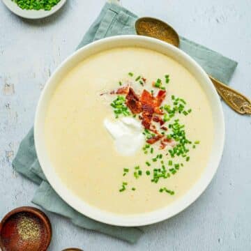 a bowl of white colored soup with chives.