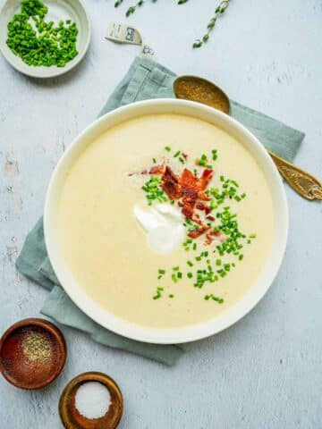 a bowl of white colored soup with chives.