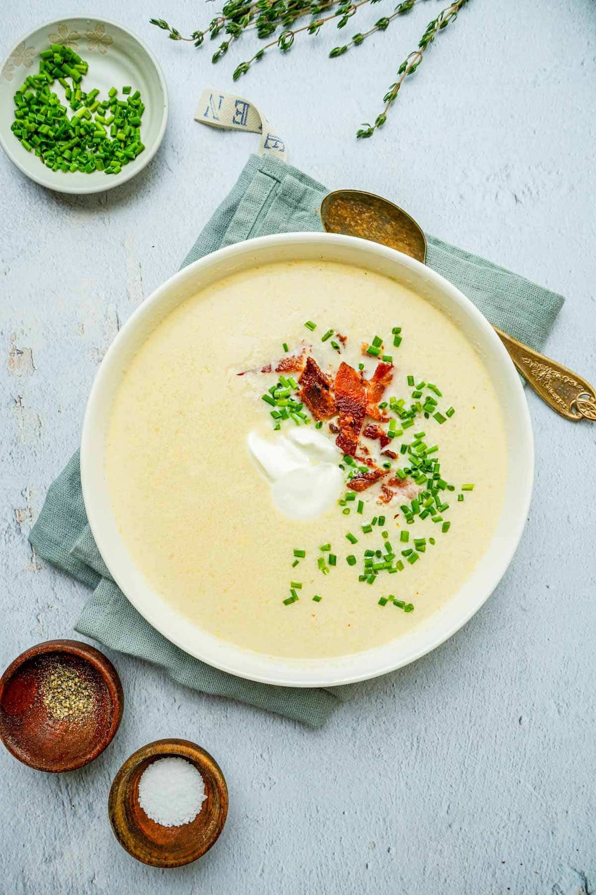 a bowl of white colored soup with chives.