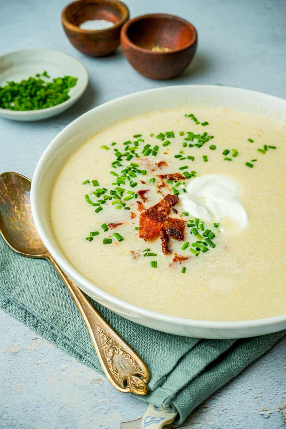 a bowl of chestnut soup with creme fraiche, chives and bacon.