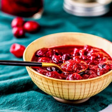 a bowl of cranberry orange chutney with a spoon.