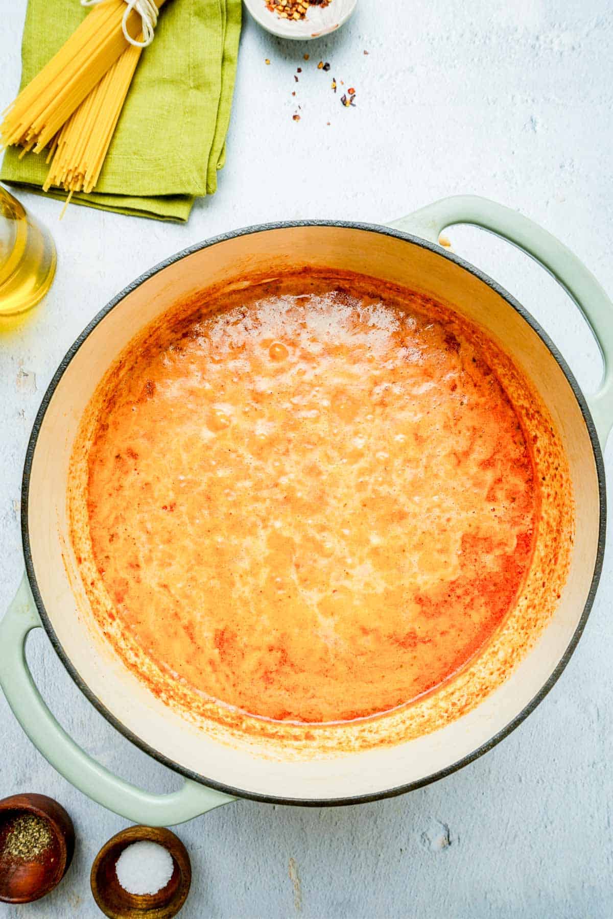 Red pepper pesto pasta sauce cooking in a pot.