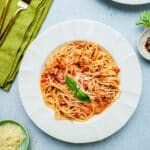 red pesto pasta in a bowl on a table.