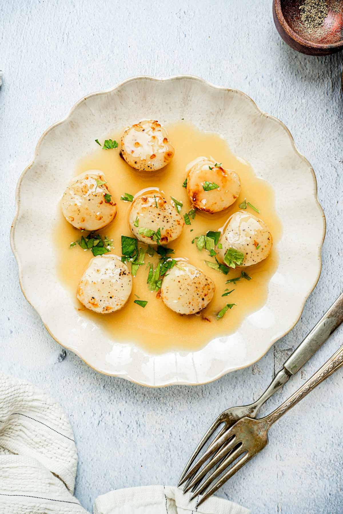 scallops on a plate with yellow sauce.