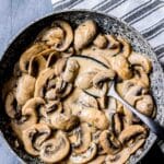 a bowl of creamy mushrooms wit a spoon.