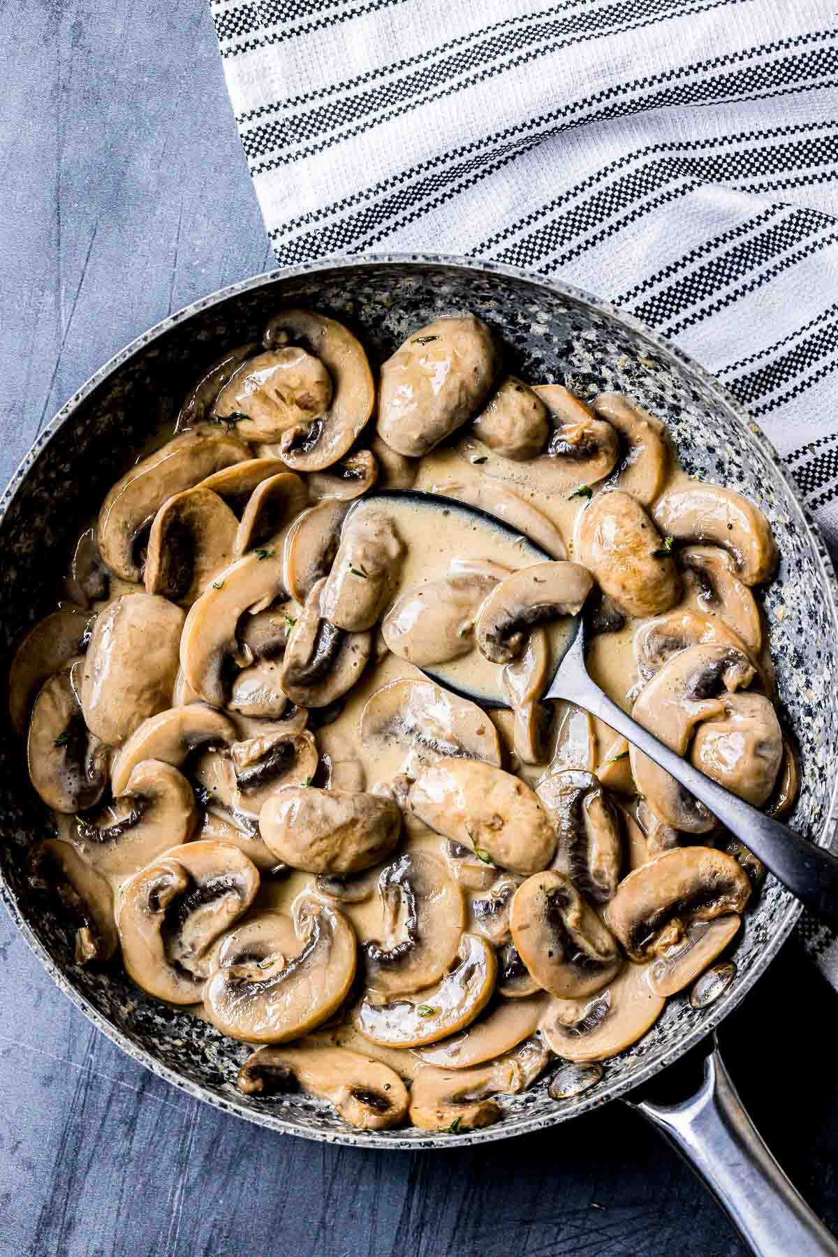 a bowl of creamy mushrooms wit a spoon.