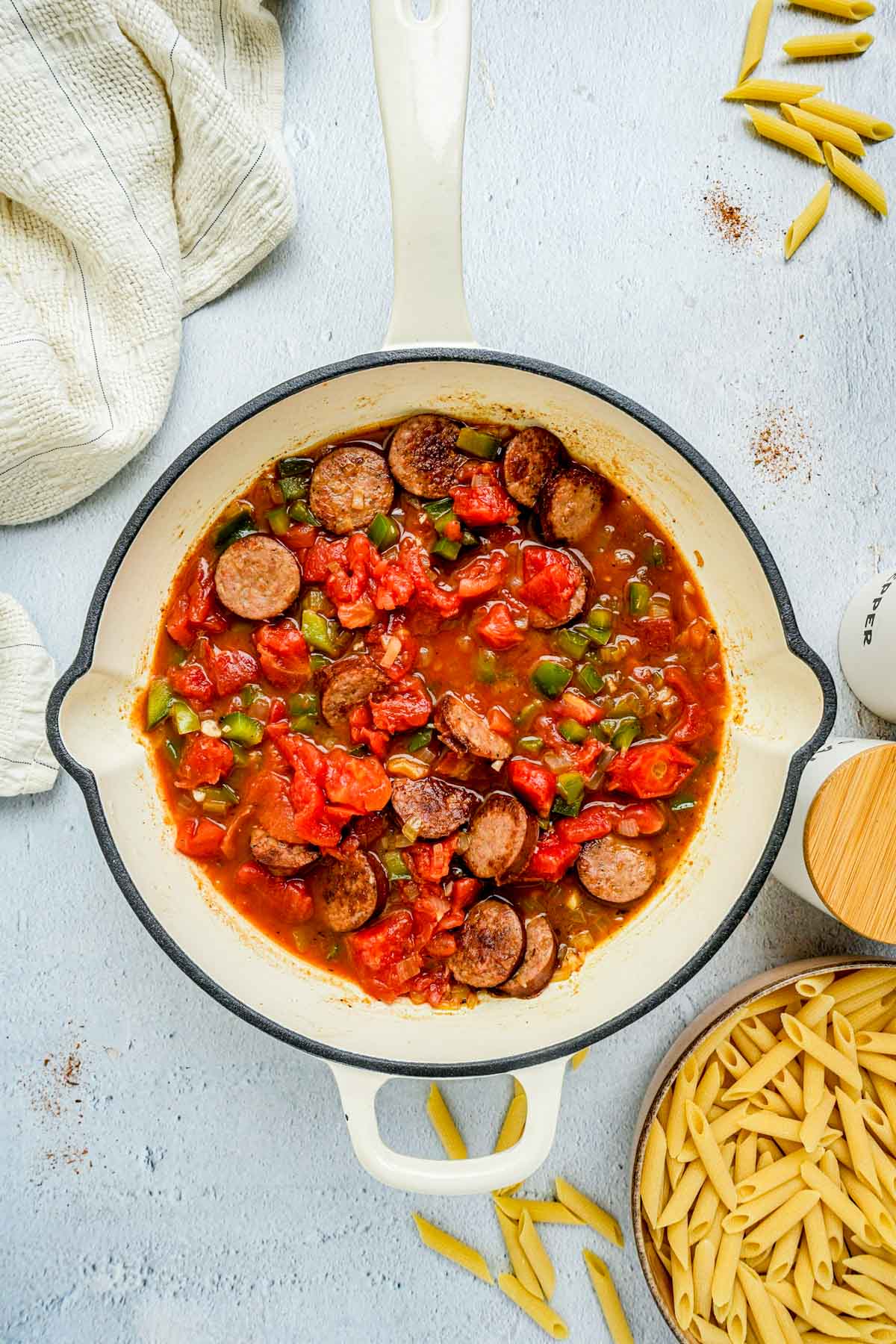 tomatoes and sausage cooking in a pan.