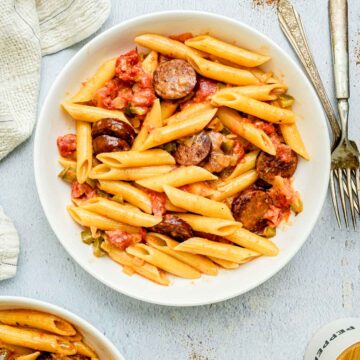 a bowl of creamy cajun pasta and tomatoes.